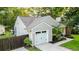 Exterior of the attached one car garage features carriage doors and mature landscaping around the driveway at 1145 Bellwood Rd, Charleston, SC 29412