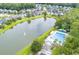 Aerial view of a community pond with fountain, swimming pool and single Gathering homes at 115 Golfview Ln, Summerville, SC 29485