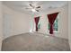 Bedroom with plush carpet, ceiling fan and bright windows draped with attractive curtains at 115 Golfview Ln, Summerville, SC 29485