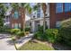 Inviting condo entrance with lush landscaping, bright white accents, and brick facade at 115 Golfview Ln, Summerville, SC 29485