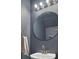 Modern bathroom with a round mirror, vanity, and dark blue walls at 117 Macy Cir, Goose Creek, SC 29445