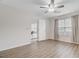Bedroom with wood-look flooring, neutral walls, ceiling fan, and a doorway to a bright living room at 117 Macy Cir, Goose Creek, SC 29445