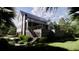 Inviting two-story home with a porch and stairs, surrounded by lush greenery and mature trees at 117 Spartina Ct, Kiawah Island, SC 29455