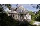 Elegant two-story home featuring a cozy porch and staircase, framed by lush trees and greenery at 117 Spartina Ct, Kiawah Island, SC 29455