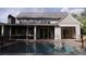 Aerial view of a two-story house featuring a backyard pool with lounge chairs and plenty of greenery at 117 Spartina Ct, Kiawah Island, SC 29455