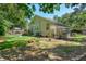 Lush backyard with green turf, a garden, a patio, and a greenhouse off the back of the house at 1227 Ocean View Rd, Charleston, SC 29412