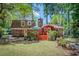 A view of the back of a brick home featuring a deck and a lush, green lawn surrounded by trees at 123 Azalea Dr, Summerville, SC 29485