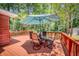 A beautiful deck with a table and chairs is covered by an umbrella on a sunny day surrounded by trees at 123 Azalea Dr, Summerville, SC 29485