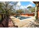 Backyard pool with a deck, built-in seating, and outdoor lounging area surrounded by mature trees at 1235 Sunset Dr, Charleston, SC 29407