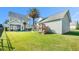 Spacious backyard with lush lawn, mature trees, and playset, all enclosed by black fencing at 125 Gaslight Blvd, Summerville, SC 29483