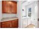 Practical laundry room with cherry cabinets, granite countertops, washer, and dryer at 125 Gaslight Blvd, Summerville, SC 29483