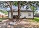 Backyard area with mature trees, fire pit, wood pile, and white siding at 1302 Aubry Dr, Moncks Corner, SC 29461
