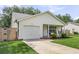 Well-maintained home with front porch seating, a garage, and a verdant lawn at 1302 Aubry Dr, Moncks Corner, SC 29461
