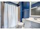 Updated bathroom features blue accent wall, shower with white curtain, and white sink vanity at 1588 Paradise Lake Dr, Mount Pleasant, SC 29464