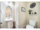 Half-bath featuring a toilet and sink plus a shelf with plants and a decorative basket at 1588 Paradise Lake Dr, Mount Pleasant, SC 29464