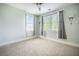 Bright bedroom features neutral carpet, ceiling fan, natural light, and modern wall sconces at 1588 Paradise Lake Dr, Mount Pleasant, SC 29464