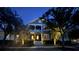 Charming two-story home with a welcoming front porch and beautifully landscaped yard at night at 1588 Paradise Lake Dr, Mount Pleasant, SC 29464