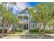 Charming blue two-story home boasts a welcoming porch and beautifully landscaped front yard on a sunny day at 1588 Paradise Lake Dr, Mount Pleasant, SC 29464