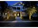 Beautiful two-story home with illuminated porch and landscaping at dusk, creating an inviting ambiance at 1588 Paradise Lake Dr, Mount Pleasant, SC 29464