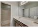 Bathroom features a white countertop, brown cabinets, mirror and vanity lighting above a tub and shower at 1589 Seabago Dr, Charleston, SC 29414