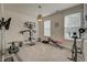 Carpeted exercise room with a full set of exercise equipment, large windows and a modern light fixture at 1589 Seabago Dr, Charleston, SC 29414