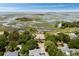 Expansive aerial view showcasing the property nestled amongst lush trees and scenic waterways at 16 Fairway Village Ln, Isle of Palms, SC 29451