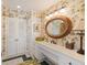 Bathroom featuring a unique oval mirror, tropical wall paper and plenty of counter space at 16 Fairway Village Ln, Isle of Palms, SC 29451