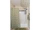 A full bathroom with a shower and tub combo, shower curtain and green accent wallpaper at 16 Fairway Village Ln, Isle of Palms, SC 29451