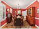 Elegant dining room featuring vibrant red walls, classic furnishings, and sophisticated lighting at 16 Fairway Village Ln, Isle of Palms, SC 29451