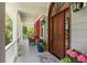 Welcoming front porch with cozy seating, lovely plants, and a stylish wooden door at 16 Fairway Village Ln, Isle of Palms, SC 29451