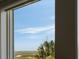 Window view of the marsh with palm trees and blue skies beyond at 16 Fairway Village Ln, Isle of Palms, SC 29451