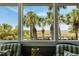 Bright window view showcasing lush palm trees and marshy landscape at 16 Fairway Village Ln, Isle of Palms, SC 29451
