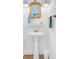 This is a pedestal sink with a decorative mirror and shelf. The space has an upscale nautical theme at 1647 Marsh Harbor Ln, Mount Pleasant, SC 29464