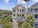 Stunning two-story home featuring a double balcony, garage, and lush landscaping with palm trees and colorful flowers at 1647 Marsh Harbor Ln, Mount Pleasant, SC 29464