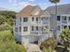 Stunning three-story beach house with multiple balconies, garage, lush landscaping, and charming coastal appeal at 1647 Marsh Harbor Ln, Mount Pleasant, SC 29464
