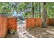 A wood fence opens up to reveal a lake and a mature tree in the backyard at 1705 Bassett Ct, Charleston, SC 29412