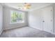 Bedroom features a ceiling fan, neutral carpet, trim, and a bright window at 1713 Pimlico Blvd, Moncks Corner, SC 29461