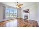 Bright living room with hardwood floors, a fireplace, a large window with a view, and a ceiling fan at 1713 Pimlico Blvd, Moncks Corner, SC 29461
