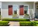 Charming home exterior featuring flower boxes beneath the windows and manicured hedges at 18 Fernandina St, Mount Pleasant, SC 29464