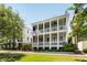 Stunning two-story home featuring double porches, a manicured lawn, and mature trees at 18 Fernandina St, Mount Pleasant, SC 29464