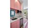 Stylish wet bar with sink, mini-fridge, and unique pink cabinetry at 18 Fernandina St, Mount Pleasant, SC 29464
