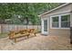 Backyard with a stone patio, picnic table, wooden fence, and surrounding trees at 1939 Oak Tree Ln, Mount Pleasant, SC 29464