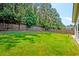 Spacious backyard with lush green grass, a wooden fence, and mature trees, perfect for outdoor activities at 195 Highwoods Plantation Ave, Summerville, SC 29485