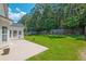 A home's backyard featuring a concrete patio and grassy lawn surrounded by trees and a fence at 195 Highwoods Plantation Ave, Summerville, SC 29485
