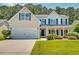 Traditional home showcasing a two-car garage, manicured landscaping, and a welcoming front porch at 195 Highwoods Plantation Ave, Summerville, SC 29485