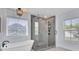 Bright bathroom with a freestanding tub and glass-enclosed shower featuring rain shower head and neutral-toned tile at 203 Plowden Mill Ct, Summerville, SC 29485