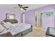 Comfortable bedroom featuring lavender walls, ceiling fan, and view into a walk-in closet at 203 Plowden Mill Ct, Summerville, SC 29485