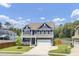 Charming two-story home features a manicured lawn, blue siding, and a two-car garage at 203 Plowden Mill Ct, Summerville, SC 29485