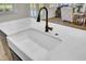 Close-up of a farmhouse kitchen sink with bronze faucet and white countertops at 203 Plowden Mill Ct, Summerville, SC 29485