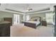 Elegant bedroom featuring a tray ceiling, beautiful furniture, and ample natural light from large windows at 203 Plowden Mill Ct, Summerville, SC 29485